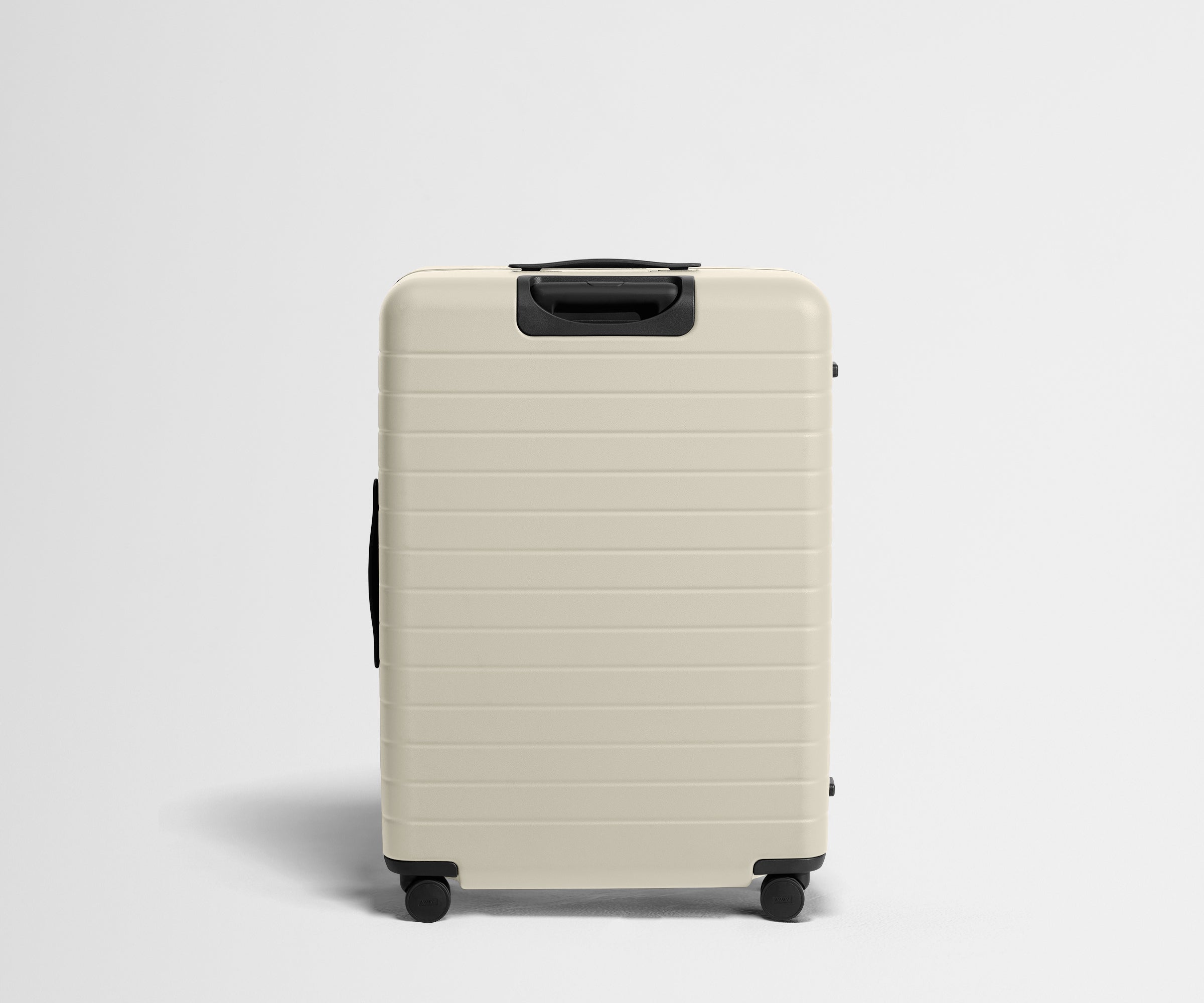 White suitcase with black handle and wheels on a light gray background