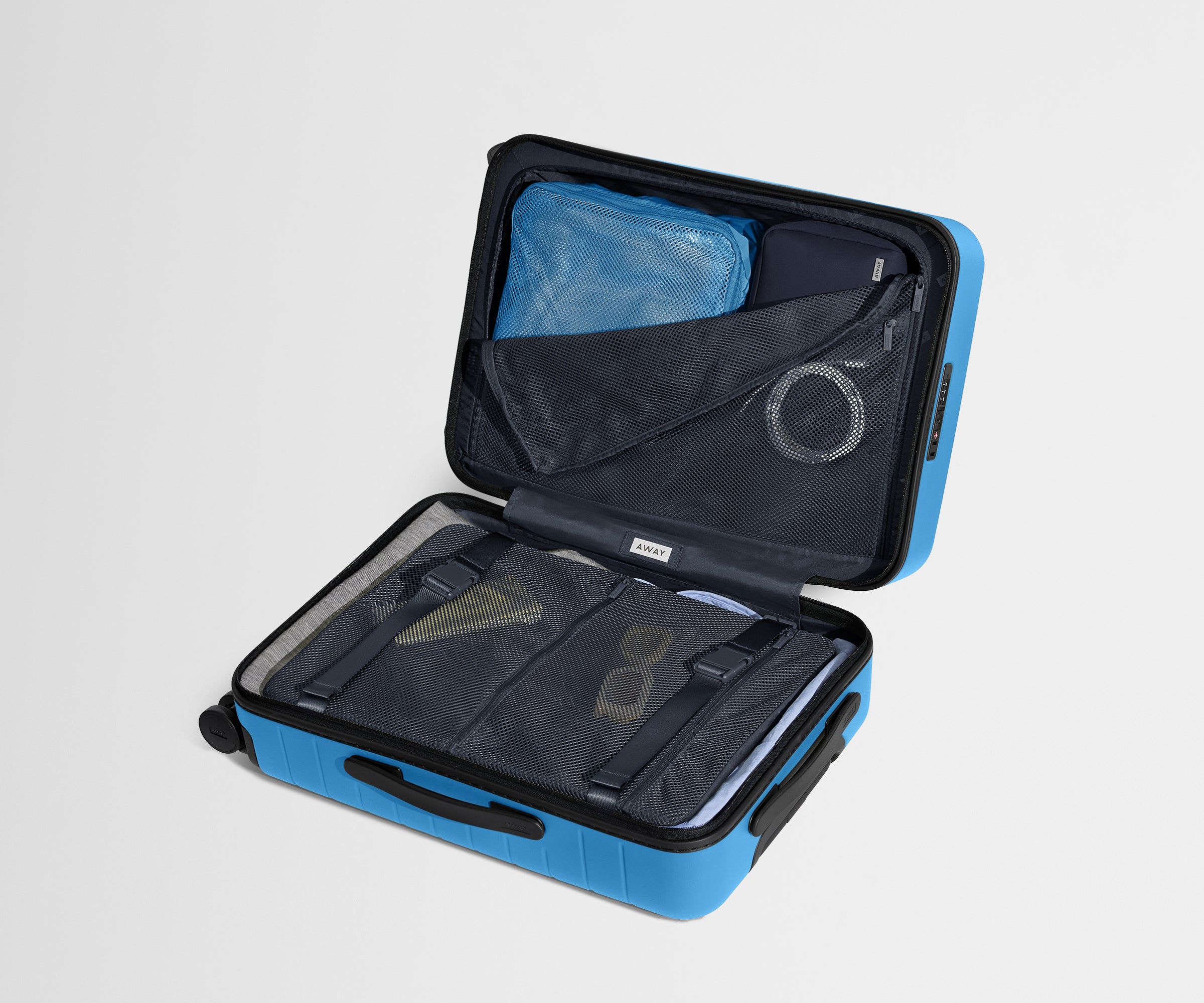 The Bigger Carry-On suitcase in Splash Blue shown open on its side and packed with Away's packing organizers to show capacity and the interior compression system, designed to help you pack more in
