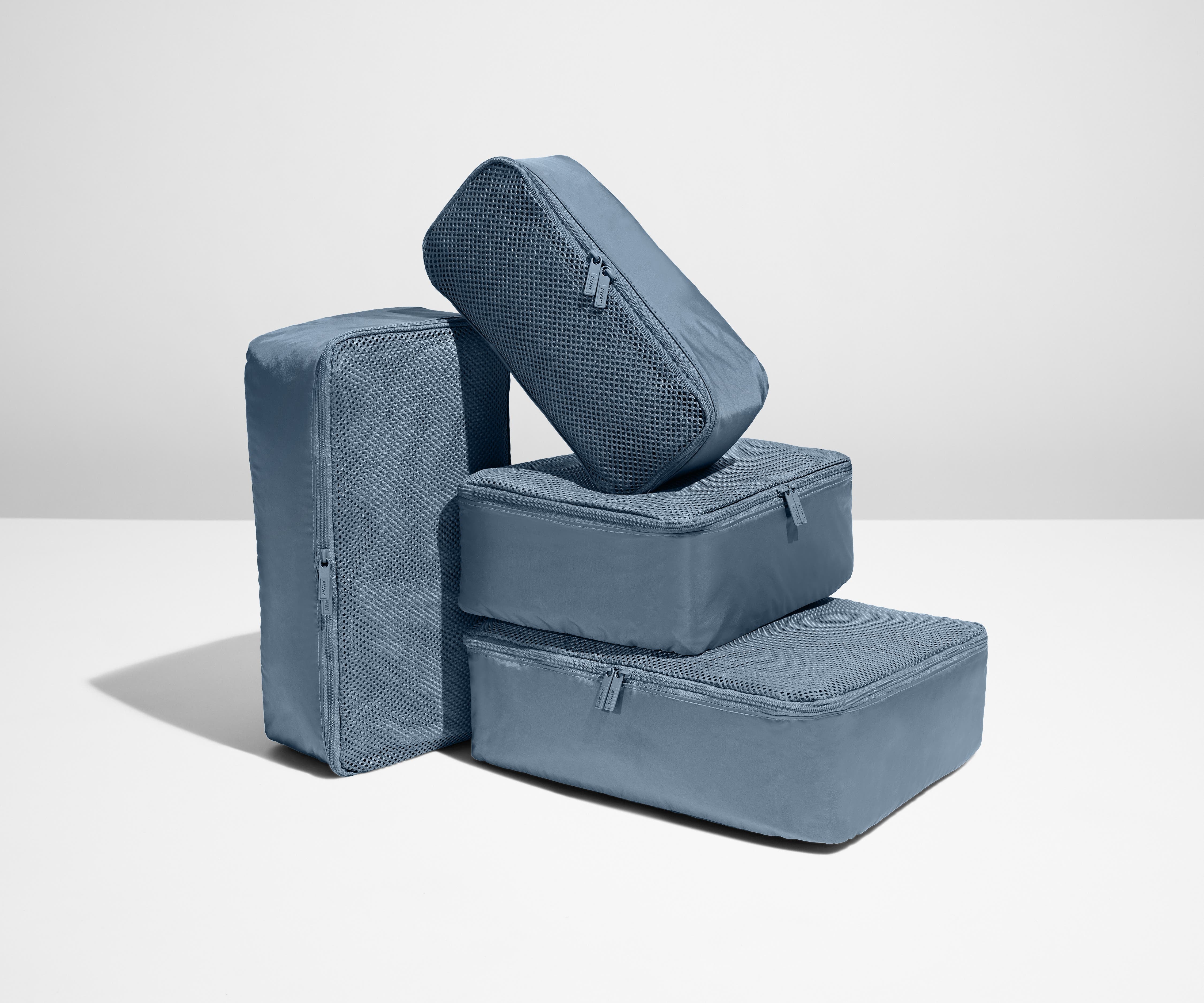 A set of four packed Insider Packing Cubes stacked on top of each other