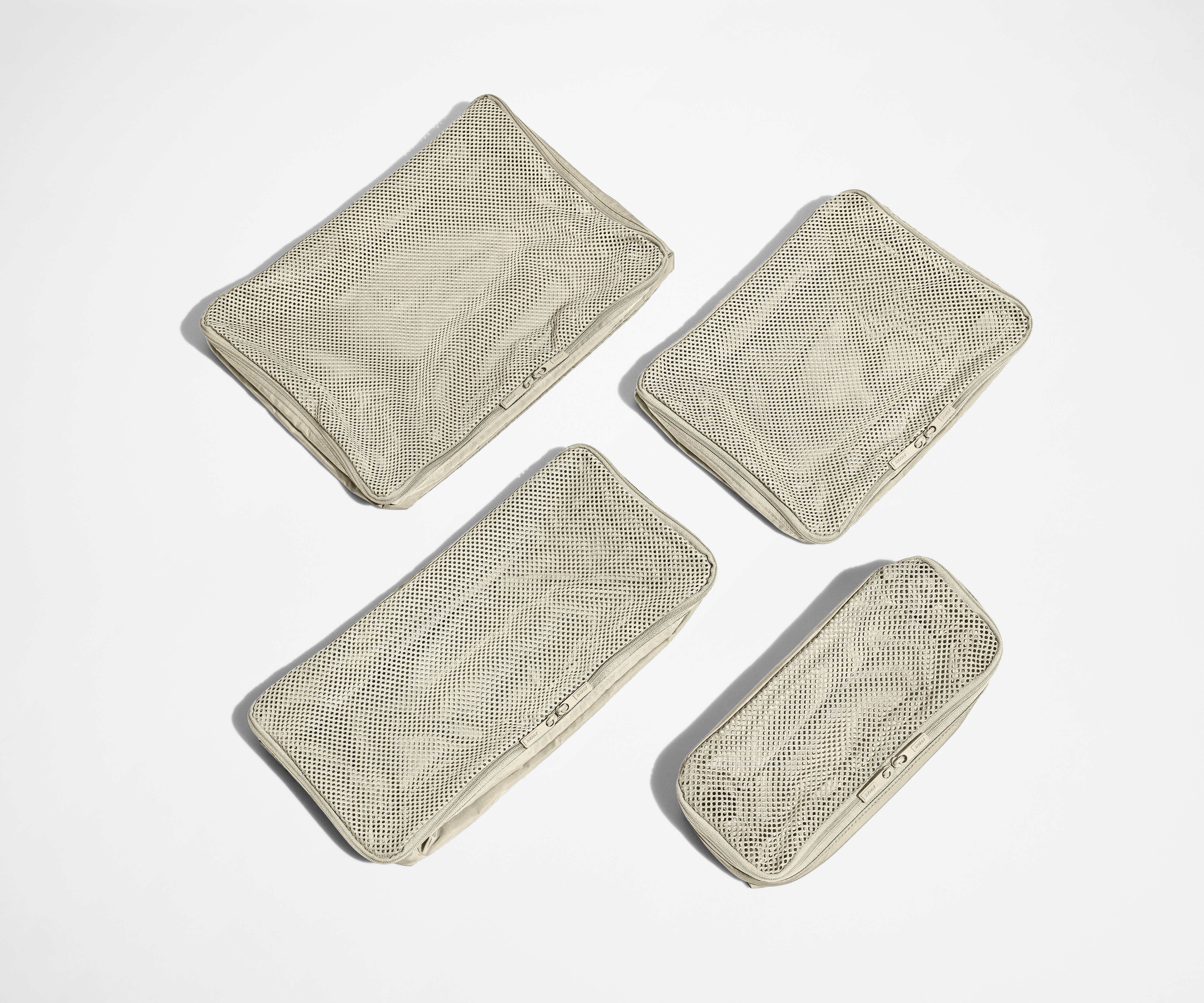 Set of four unpacked Packing Cubes laying flat