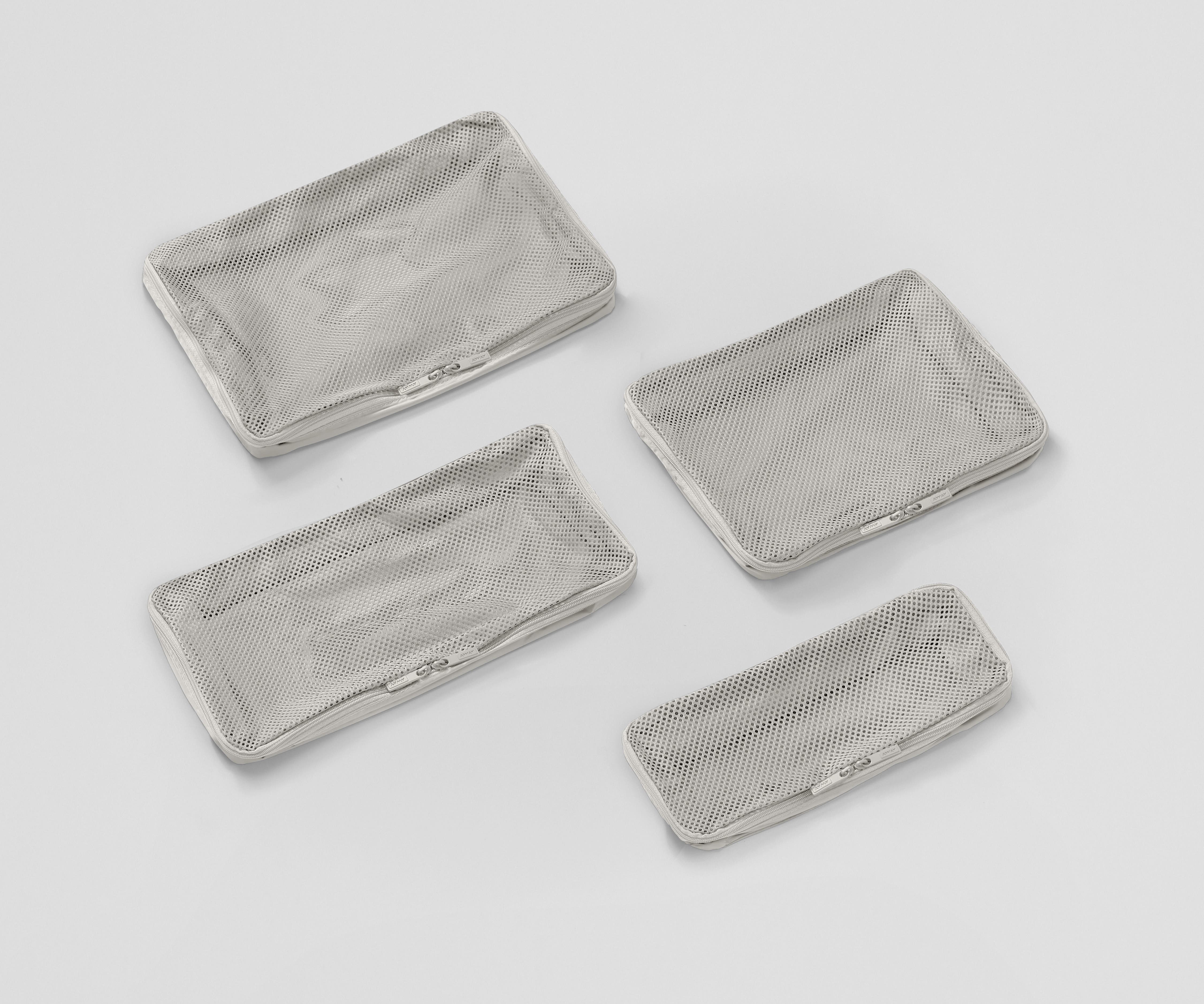 Set of four unpacked Packing Cubes laying flat