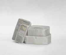 A set of four packed Insider Packing Cubes stacked on top of each other