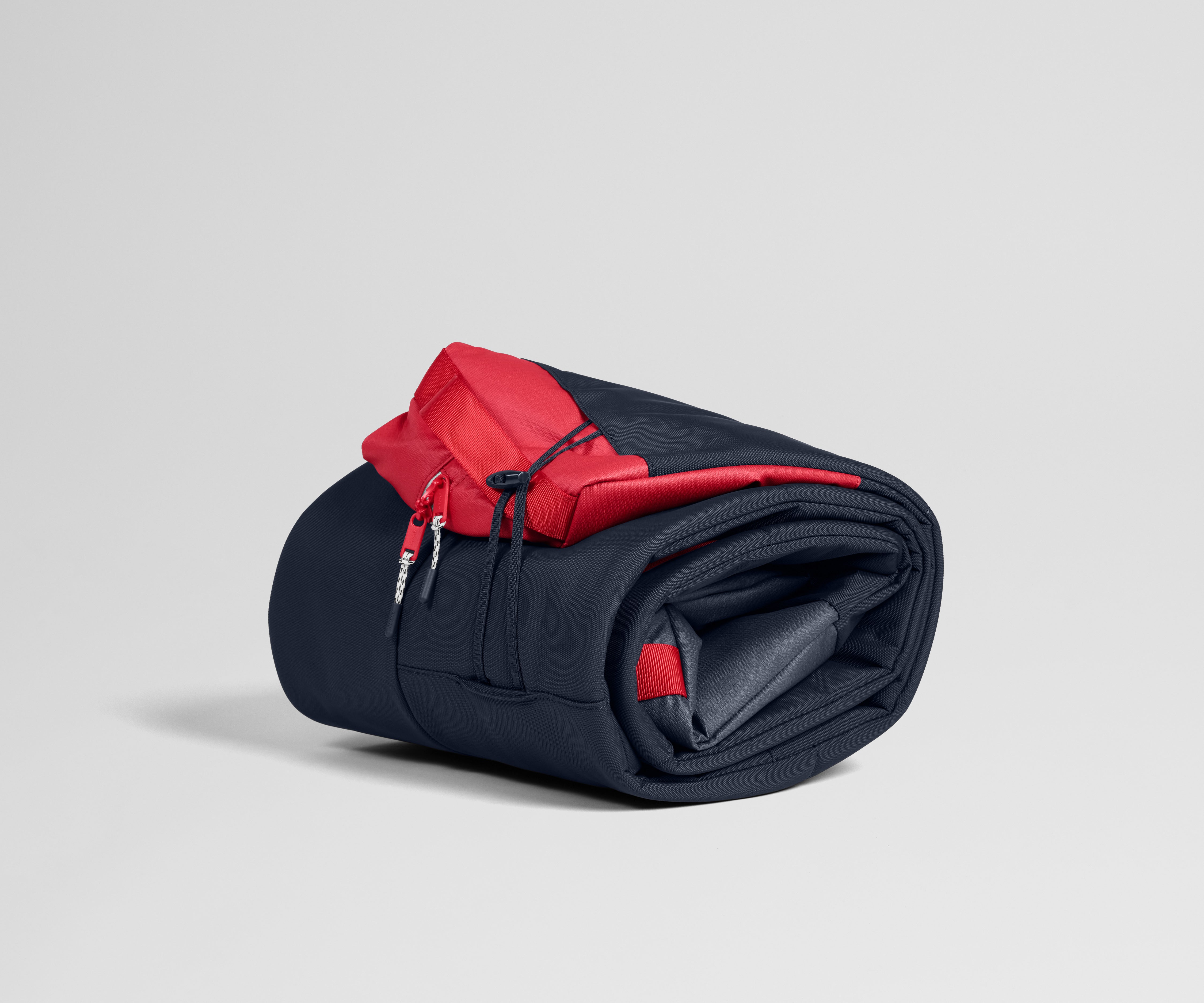 Roll-up ski bag with red accents on a light gray background