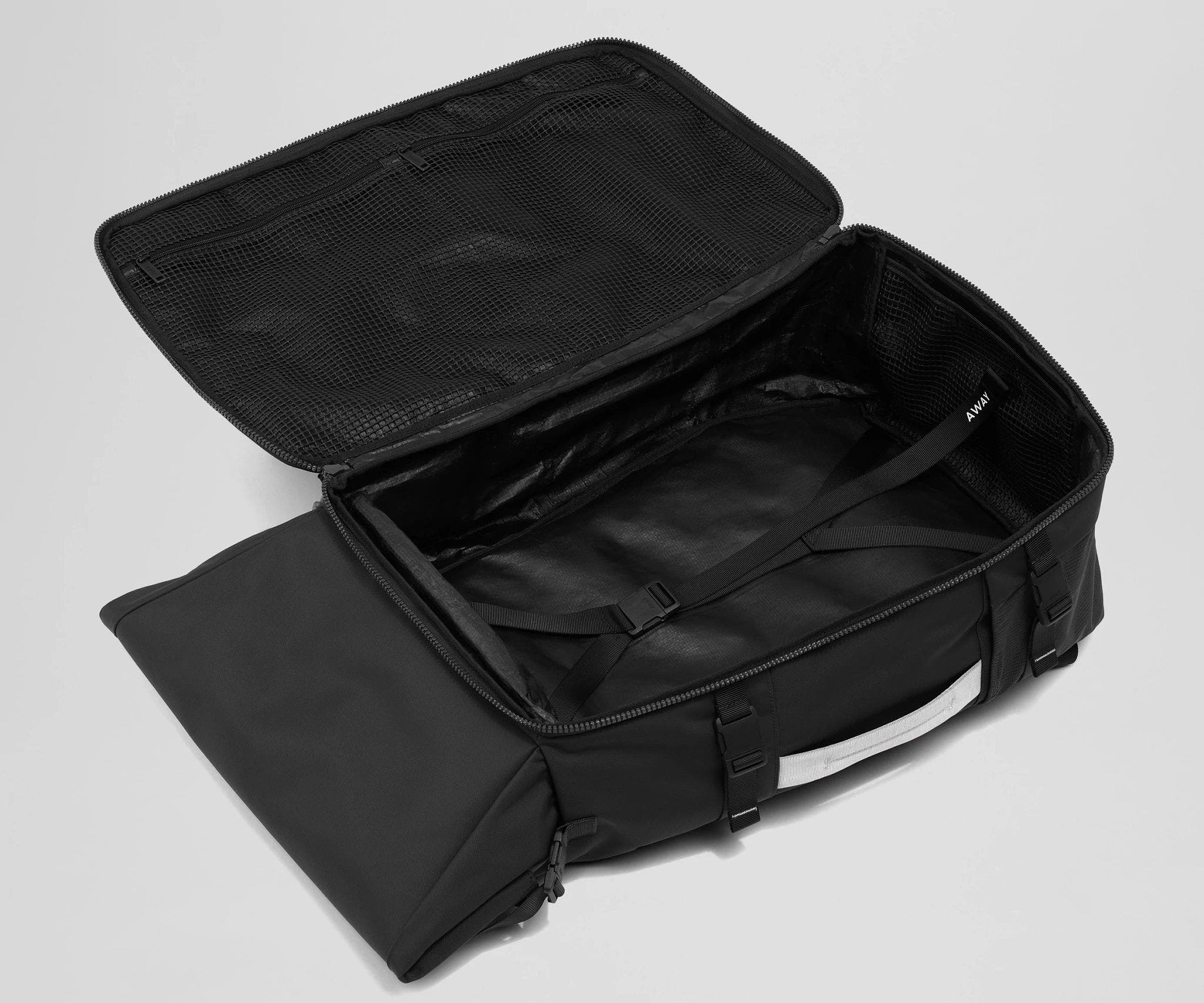 Open, unpacked Carry-On Boot Bag 55L showing the mesh zipper pockets and compression straps