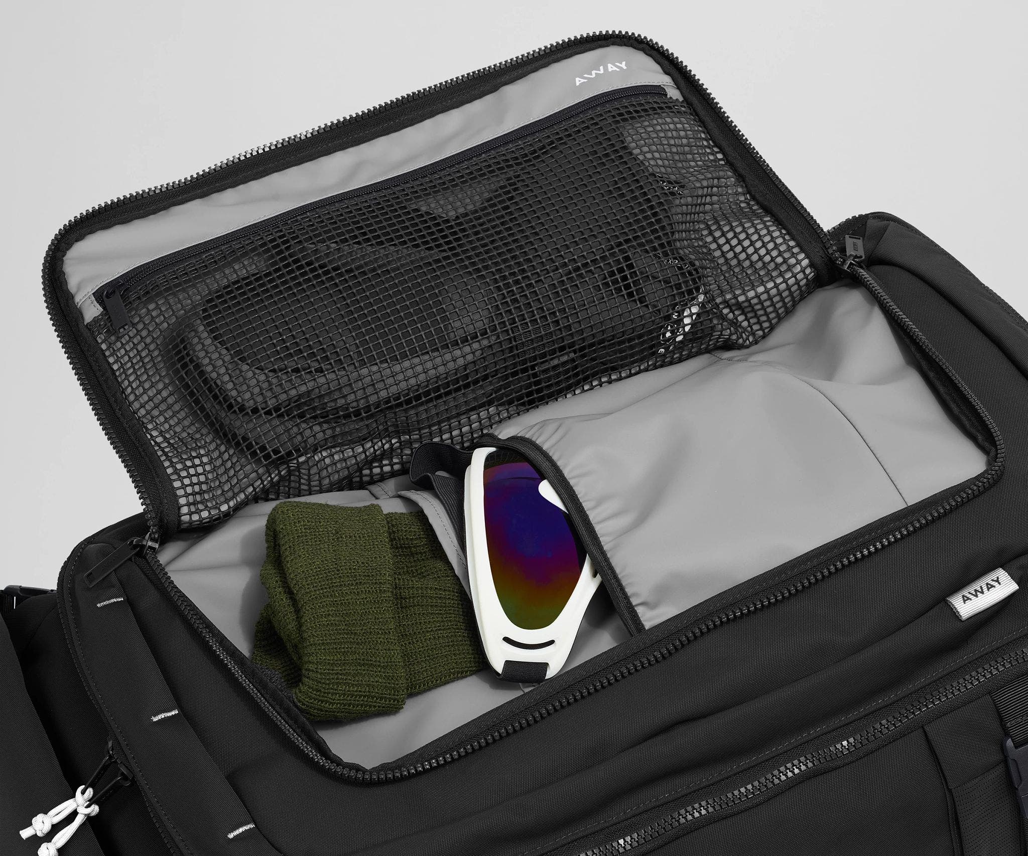 Gloves, beanie, and ski googles packed in the front flap pocket