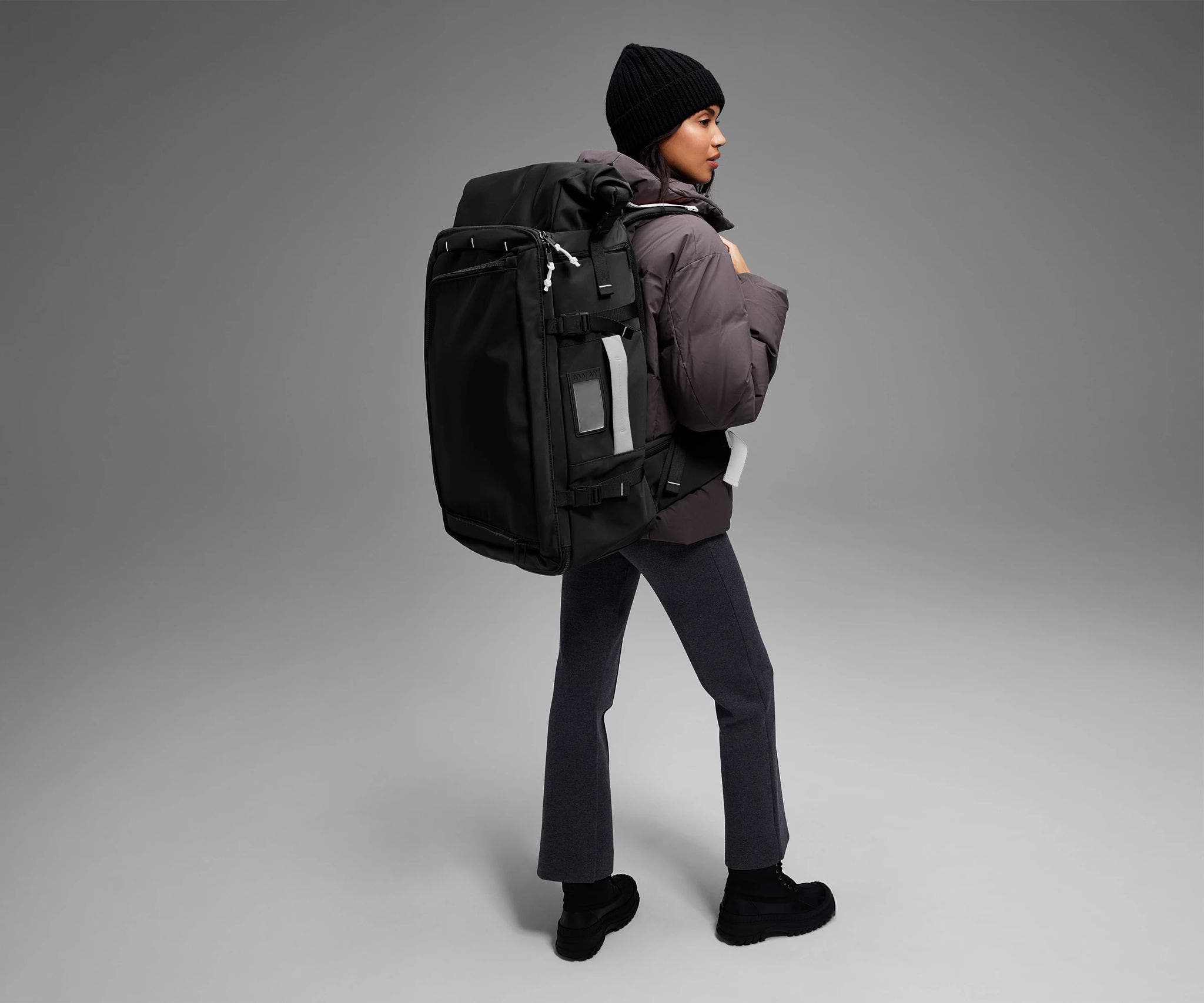 5'9" person wearing the 55L Boot Bag and winter clothes