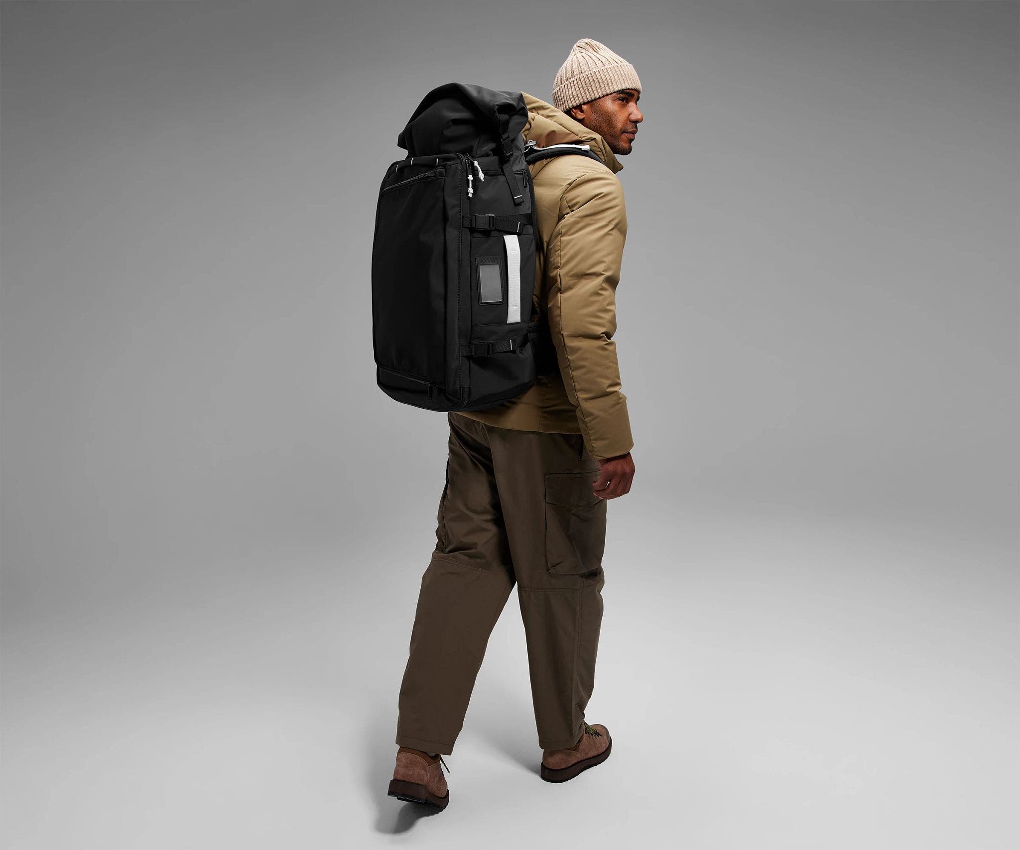 6'2" person wearing the 55L Boot Bag and winter clothes