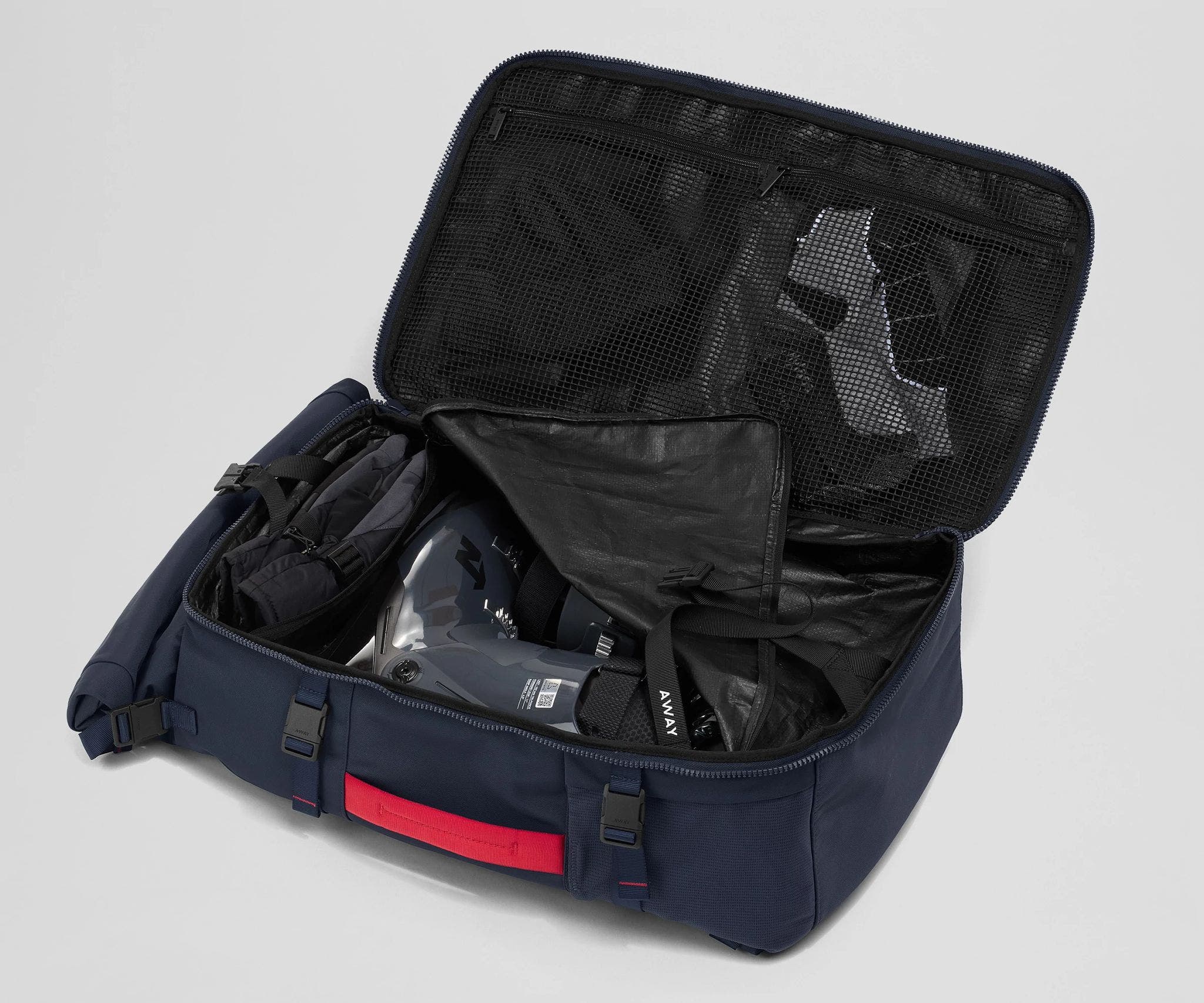 Ski boots packed into the removable boot cube inside the Boot Bag. Winter hat and clothing in the front mesh pockets