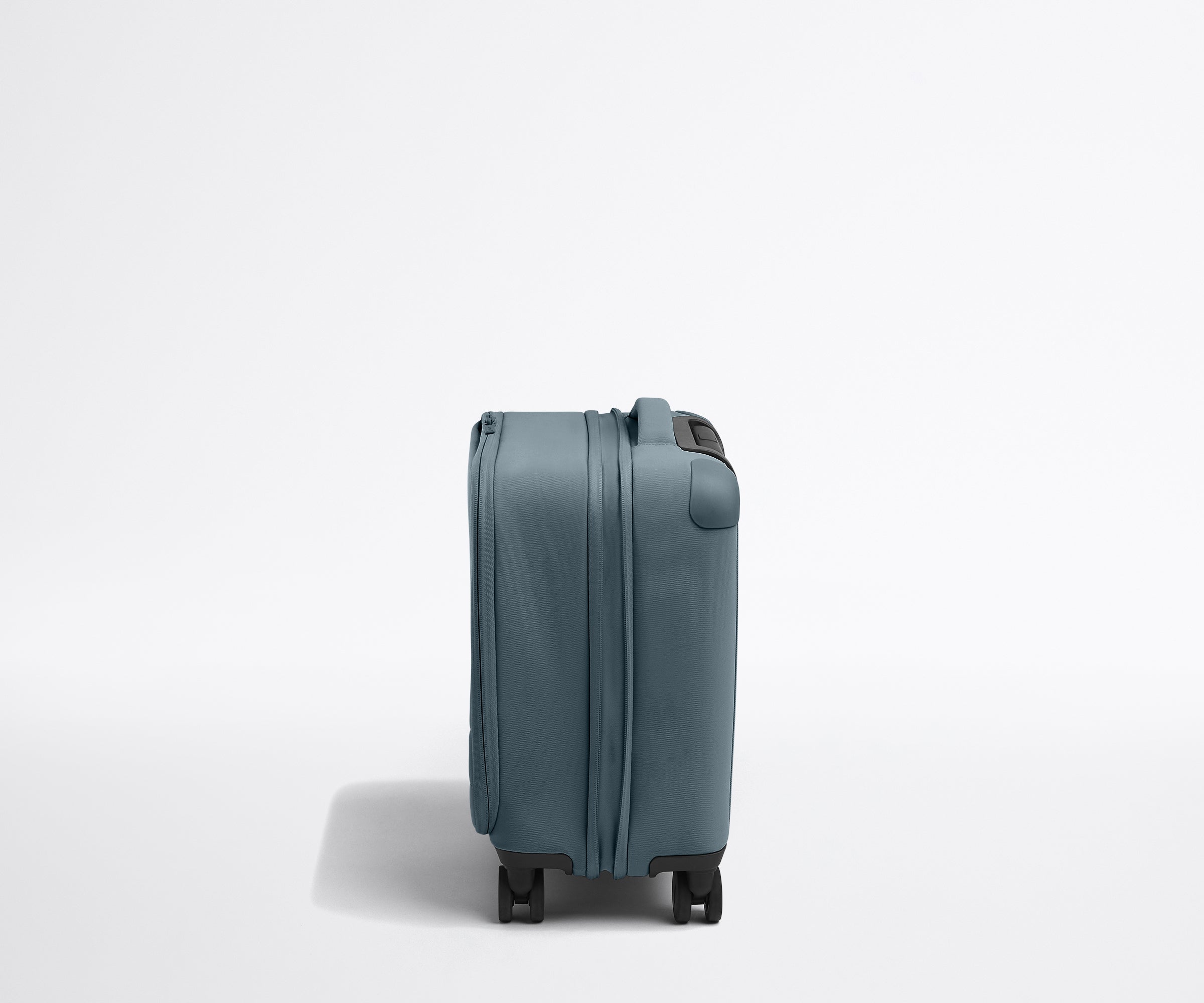 Side product view of The Softside Compast Carry-On suitcase in Coast Blue shown fully expanded
