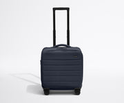 Front product view of The Softside Compact Carry-On suitcase in Navy Blue with raised handle