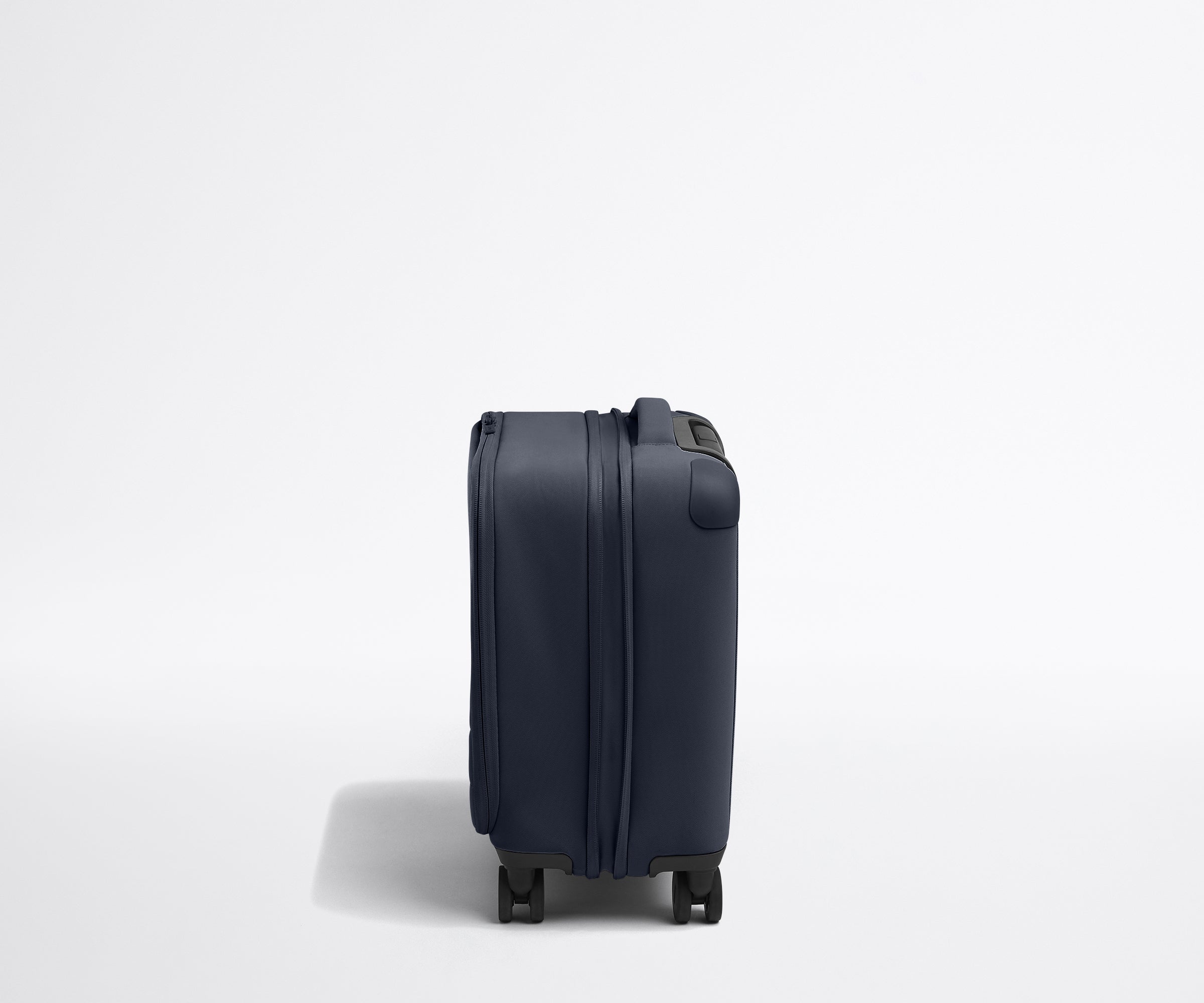 Side product view of The Softside Compast Carry-On suitcase in Navy Blue shown fully expanded