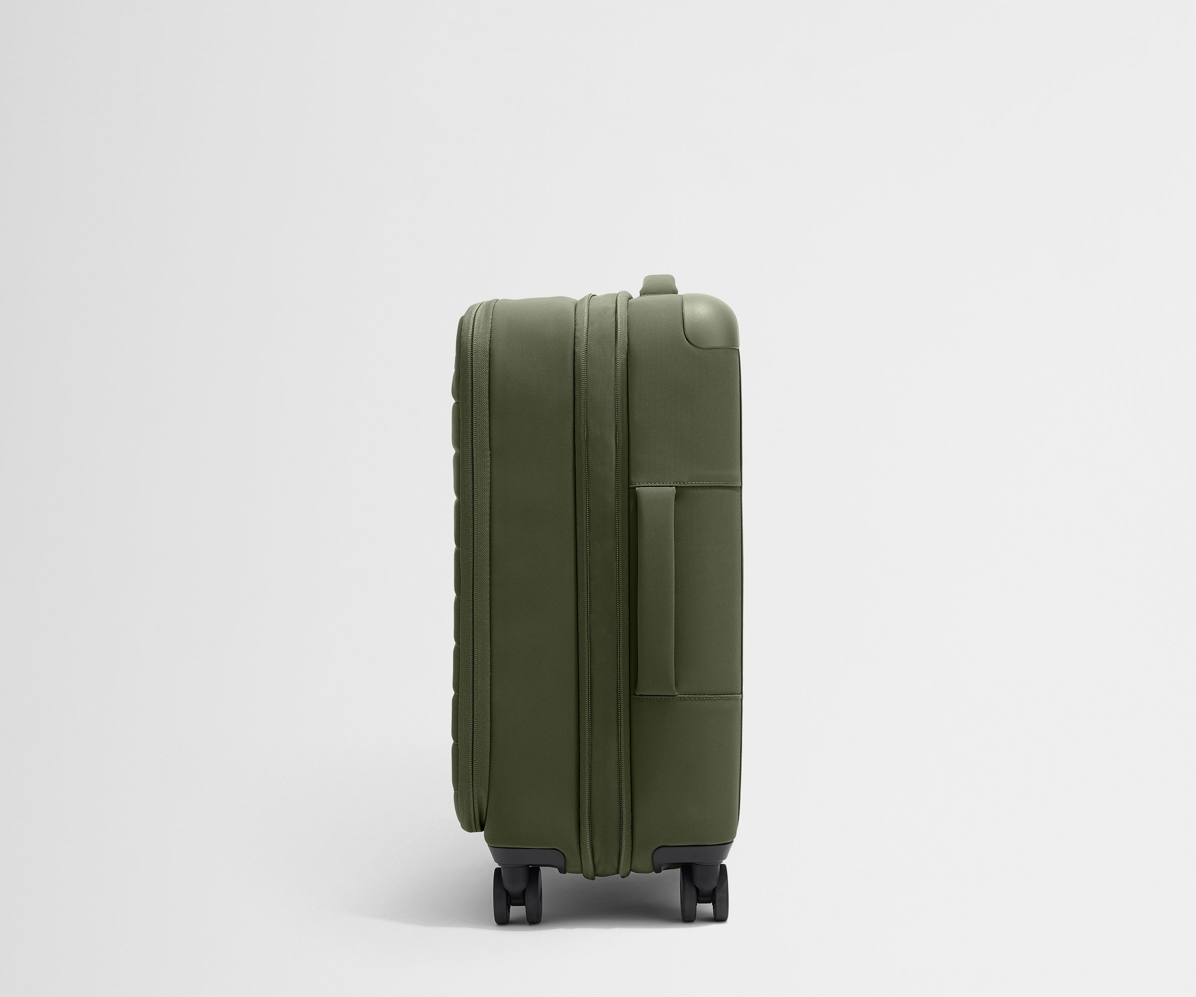 Side product view of The Softside Bigger Carry-On suitcase in Olive Green shown fully expanded