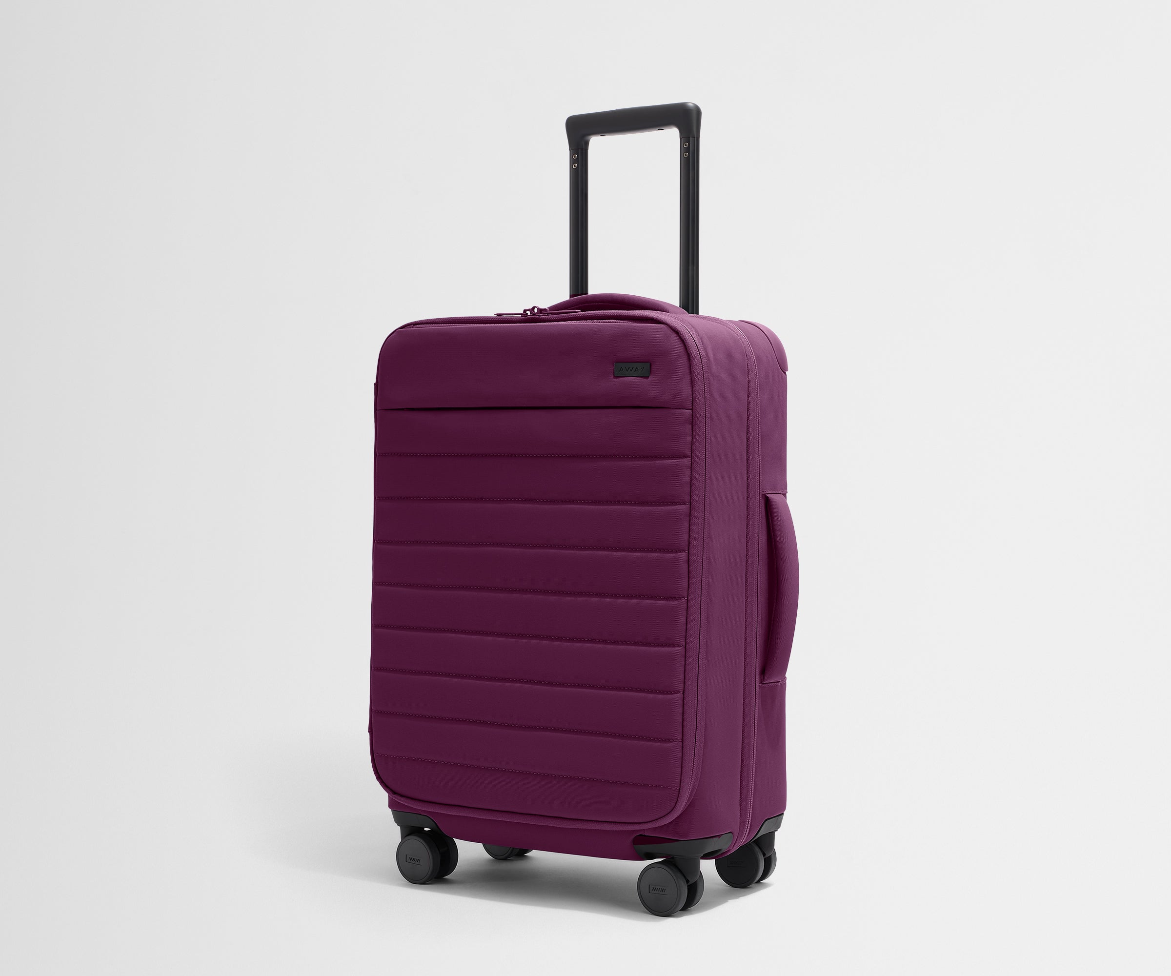 Angled product view of The Softside Bigger Carry-On suitcase in Plum Purple with raised handle