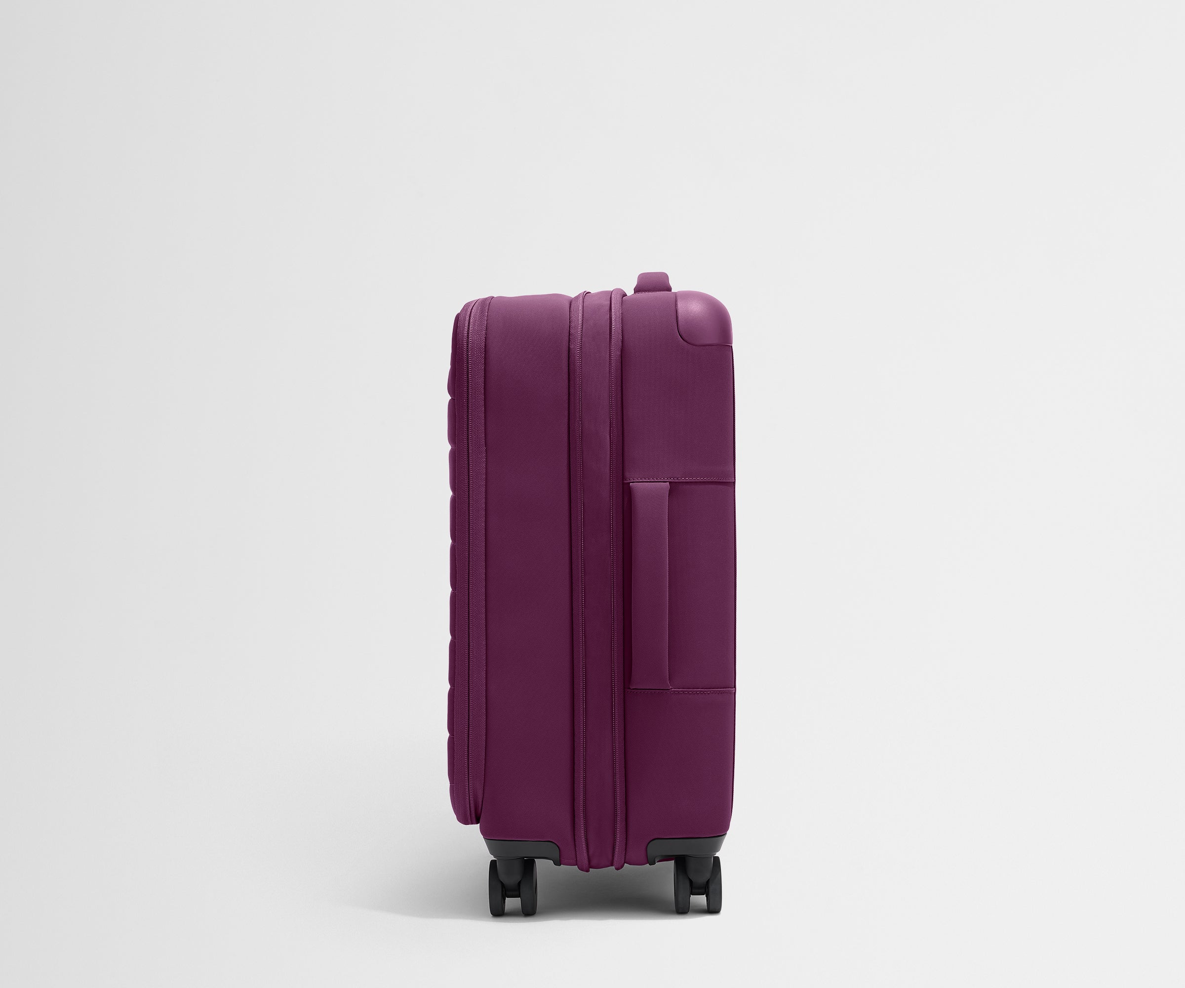 Side product view of The Softside Bigger Carry-On suitcase in Plum Purple shown fully expanded