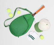 Green tennis bag with tennis racket, balls, and cap on a white background