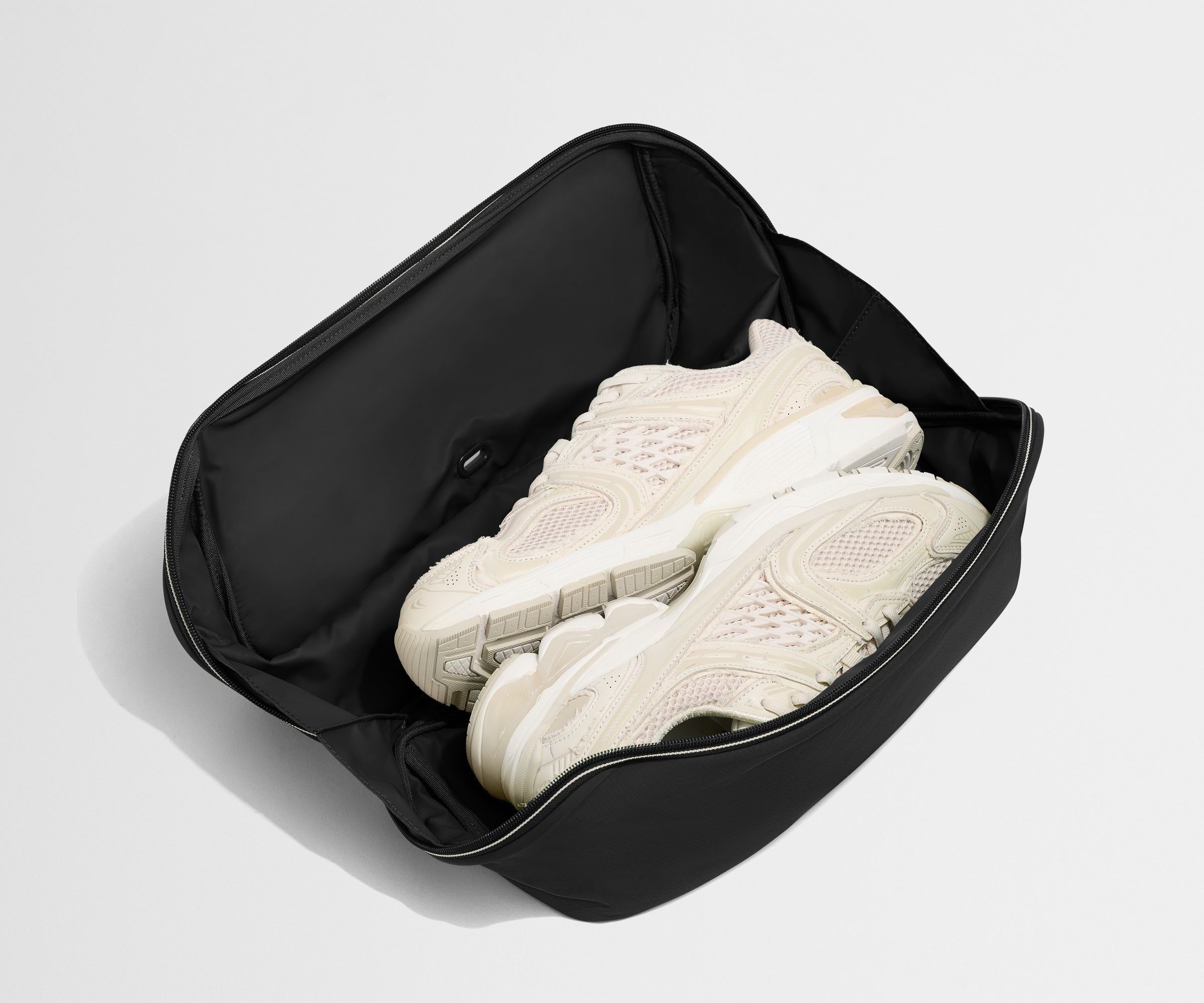 Black shoe organizer with white sneakers on a light gray background