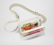 The clear Stadium Bag with strap is packed with things like a phone, jewelry, and hair ties, and shown how clear it is to meet stadium and venue regulations