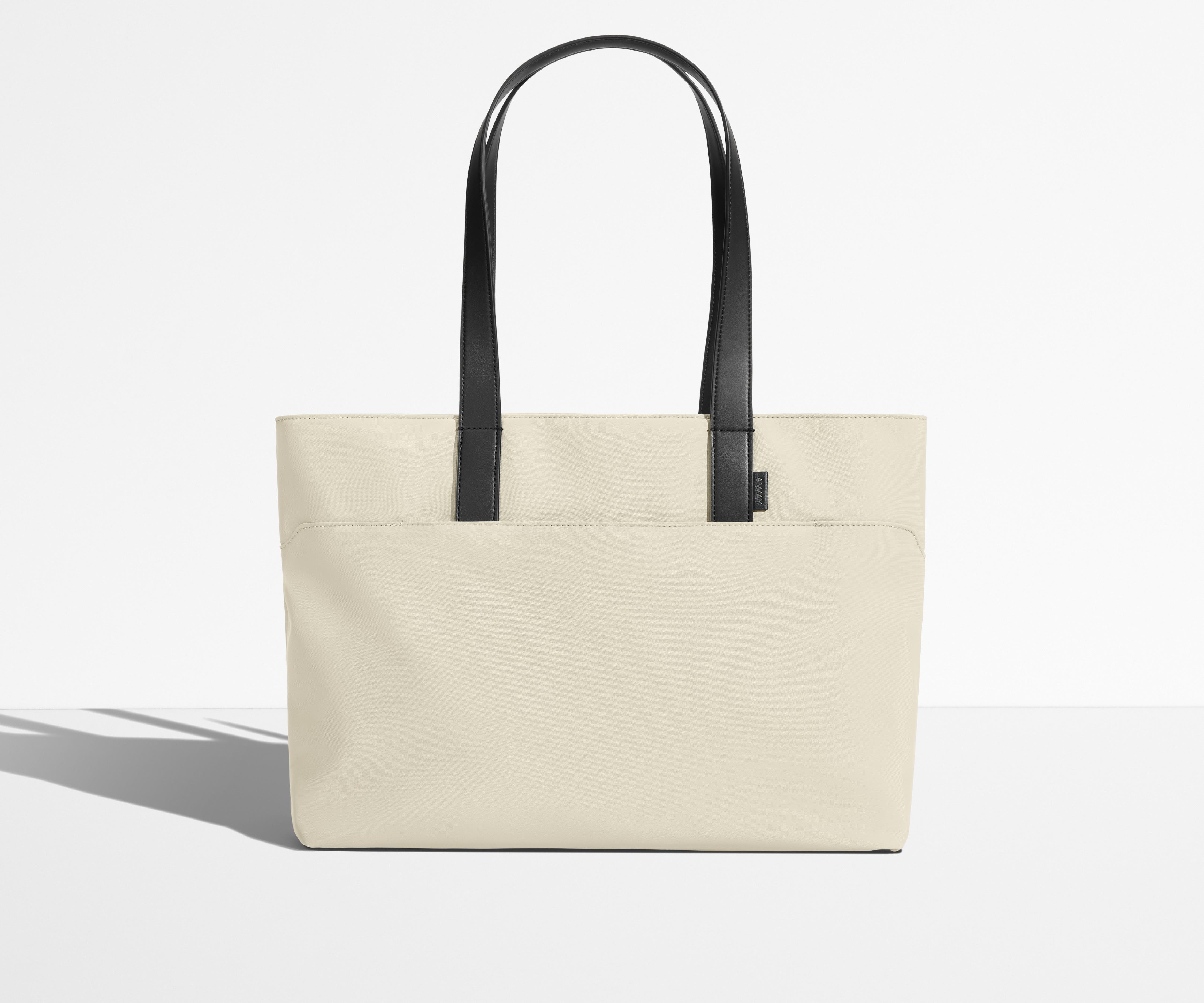 Front view of The Everywhere Tote with its leather handles up