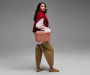 Person wearing the Train Case on their shoulder using the detachable shoulder strap