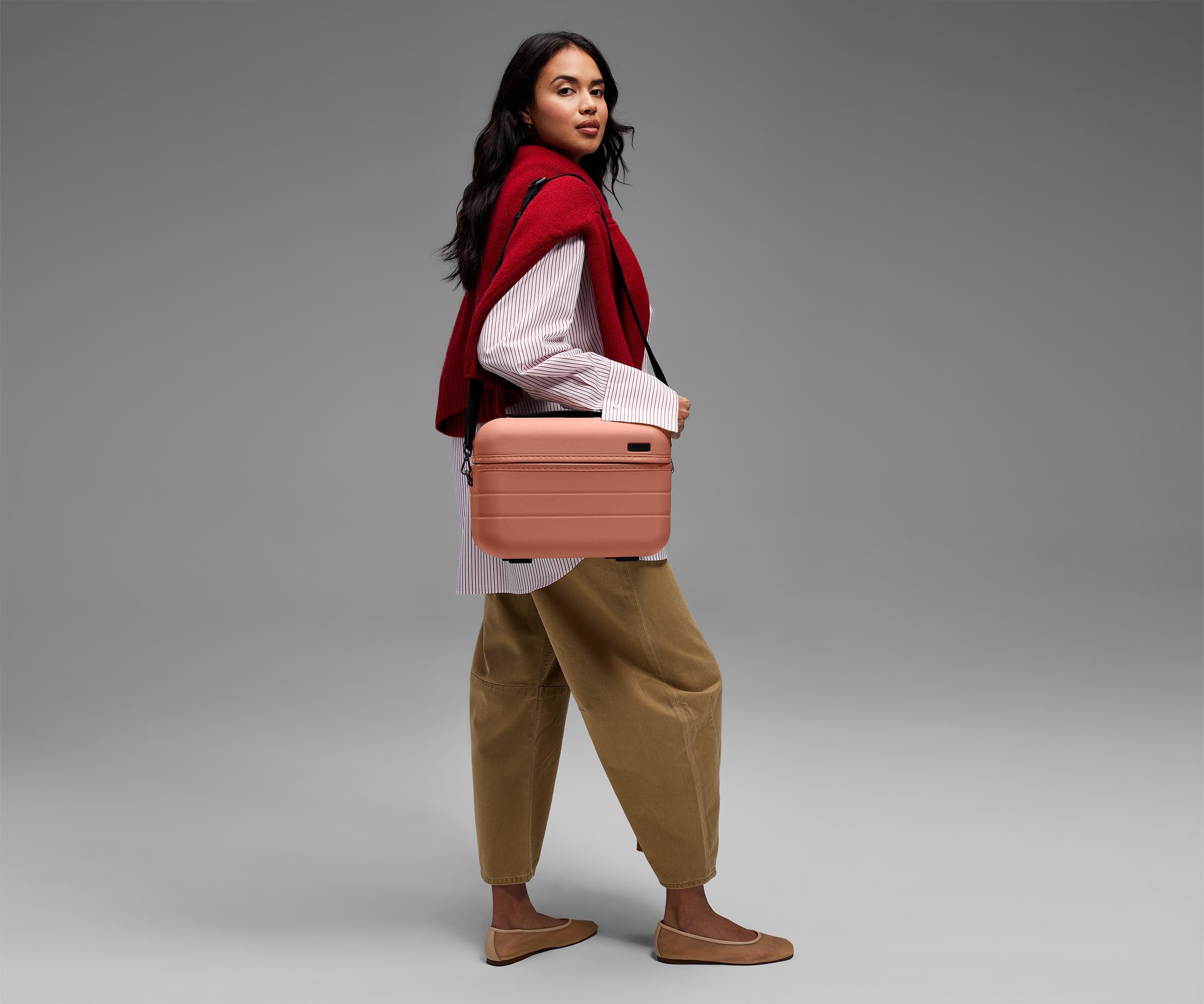 Person wearing the Train Case on their shoulder using the detachable shoulder strap