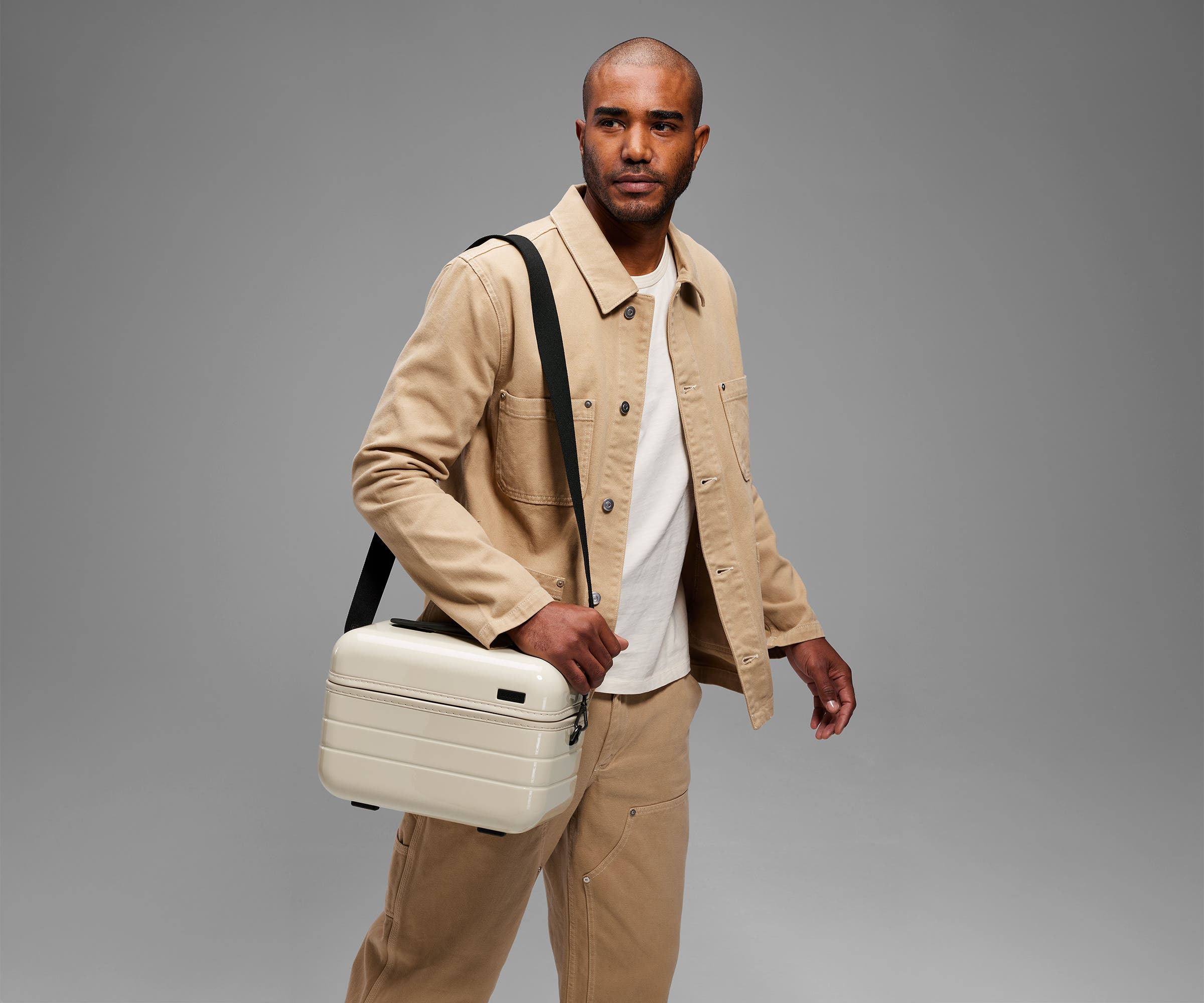 Person wearing the Train Case on their shoulder using the detachable shoulder strap