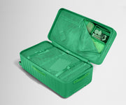 The Trunk suitcase in Palm Green shown open on its side and packed with Away's packing organizers to show capacity and the interior compression system, designed to help you pack more in