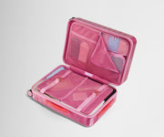 The Bigger Carry-On suitcase in Translucent Pink shown open on its side and packed with Away's packing organizers to show capacity and the interior compression system, designed to help you pack more in
