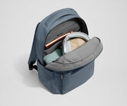 Main compartment of the Commuter Backpack packed with a notebook, light layers, and headphones