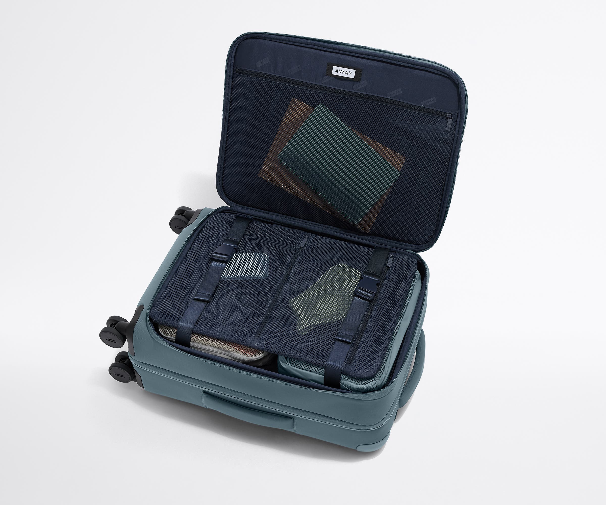 Open Softside Bigger Carry-On suitcase, with travel essentials in the front flap pocket and compression pad pockets