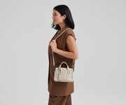 Person wearing the Mini Everywhere Bag on their shoulder using the removable shoulder strap