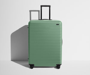 Front product view of The Large suitcase in Sea Green with raised handle
