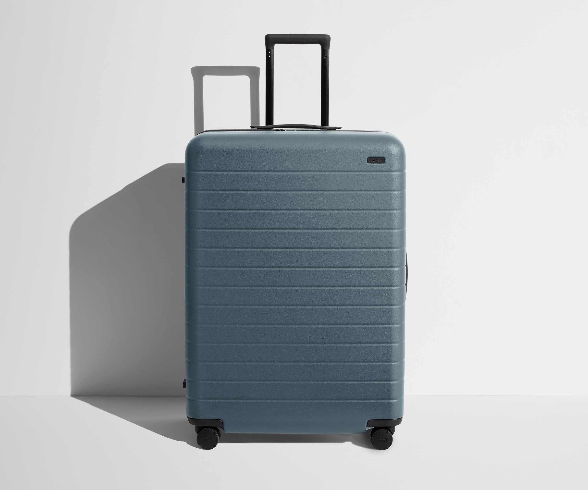 Front product view of The Large suitcase in Coast Blue with raised handle