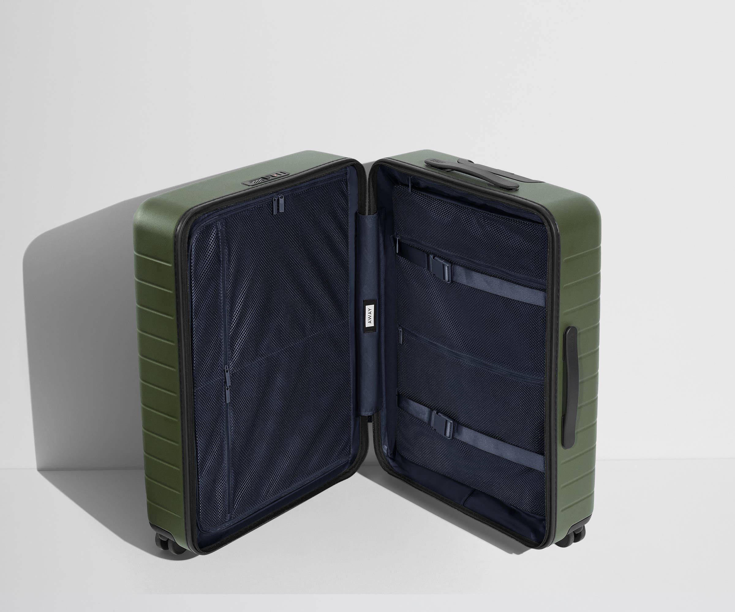 The Medium suitcase in Olive Green shown open in an upright position to show interior organization and compression system
