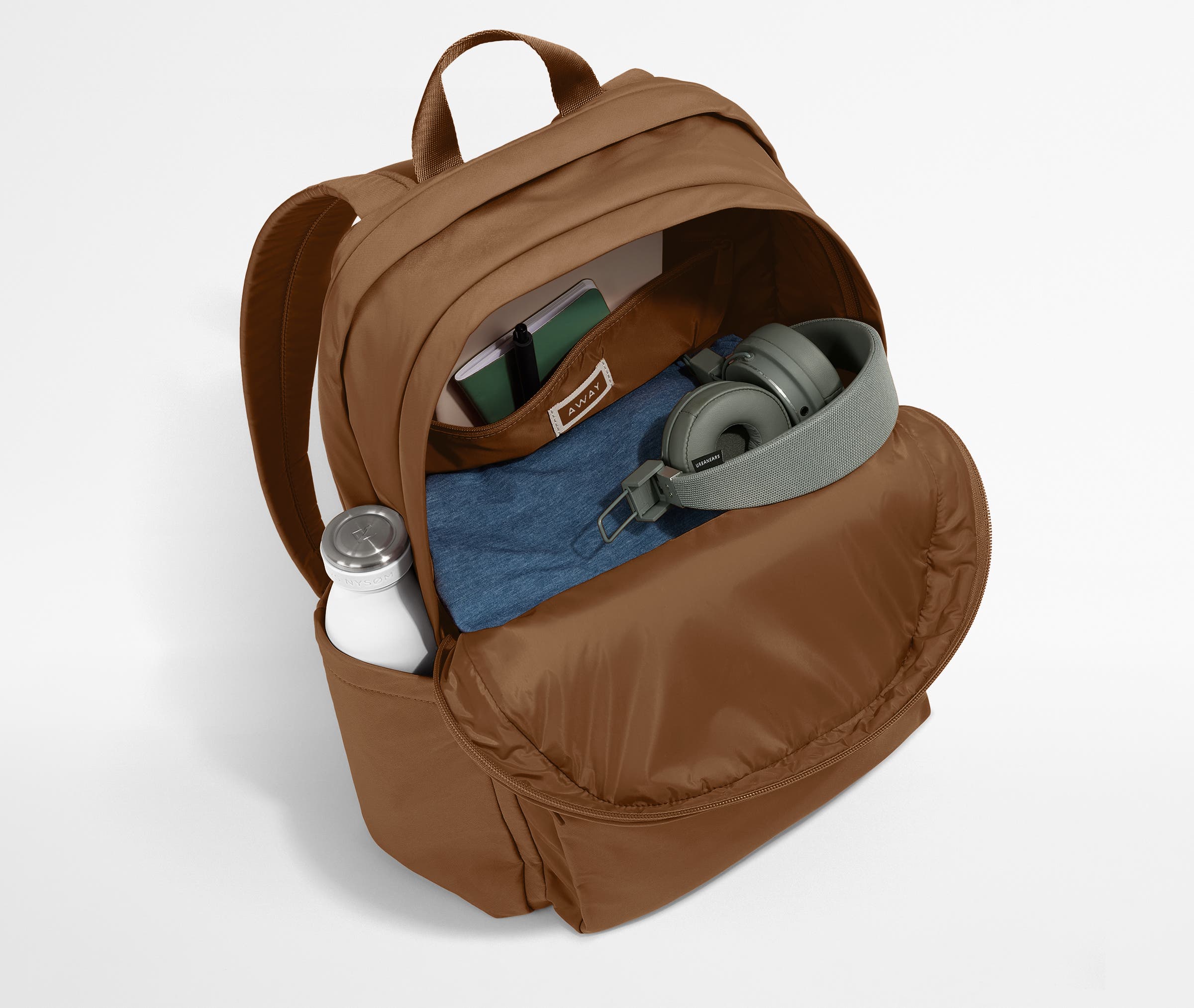 Front compartment packed with a notebooks, headphones, and clothing