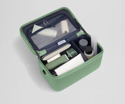 Train case packed with multiple grooming essentials, including a razor, nail care, and lotions