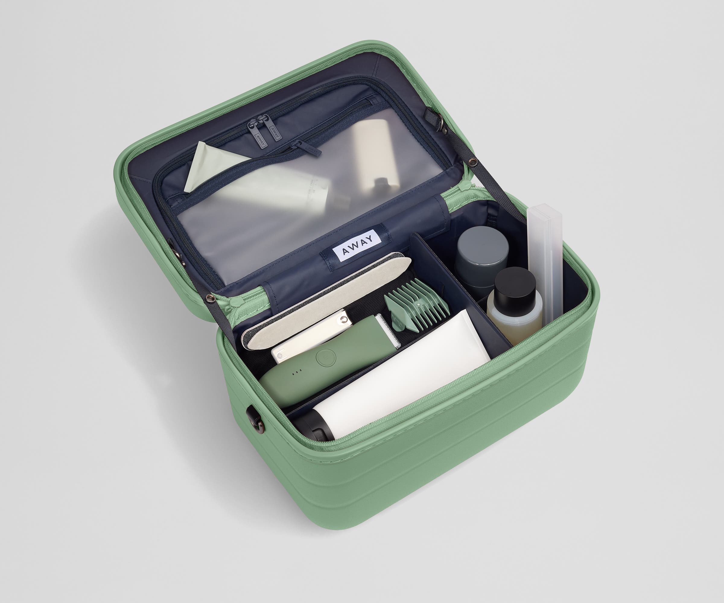 Train case packed with multiple grooming essentials, including a razor, nail care, and lotions