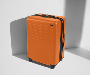 Angled product view of The Large Flex suitcase in Sorbet Orange