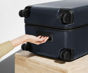 The Trunk suitcase in Navy Blue shown from below highlighting the underside grab handle