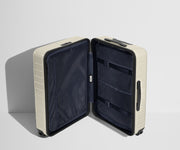 The Medium suitcase in Salt White (Gloss) shown open in an upright position to show interior organization and compression system