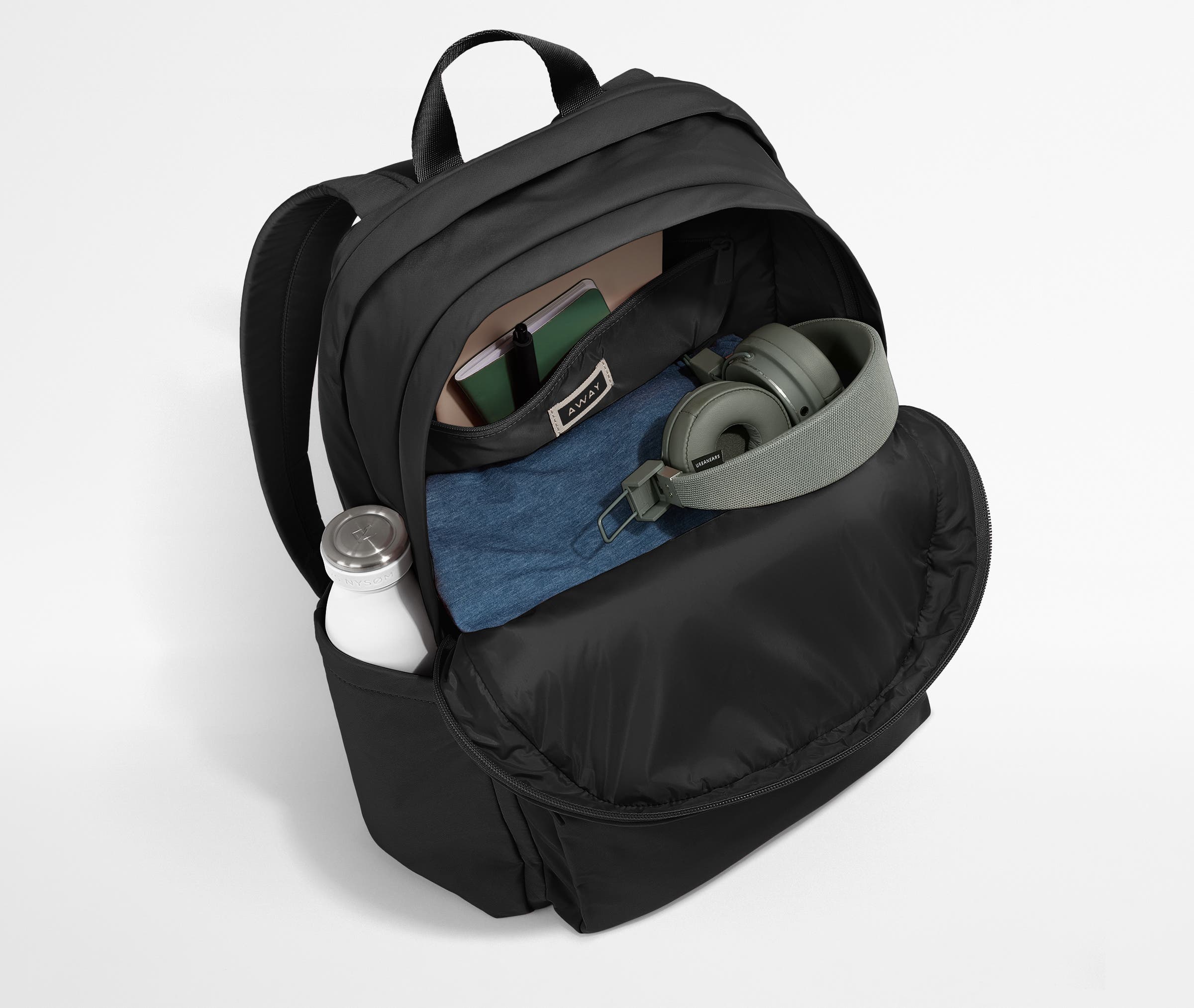 Front compartment packed with a notebooks, headphones, and clothing