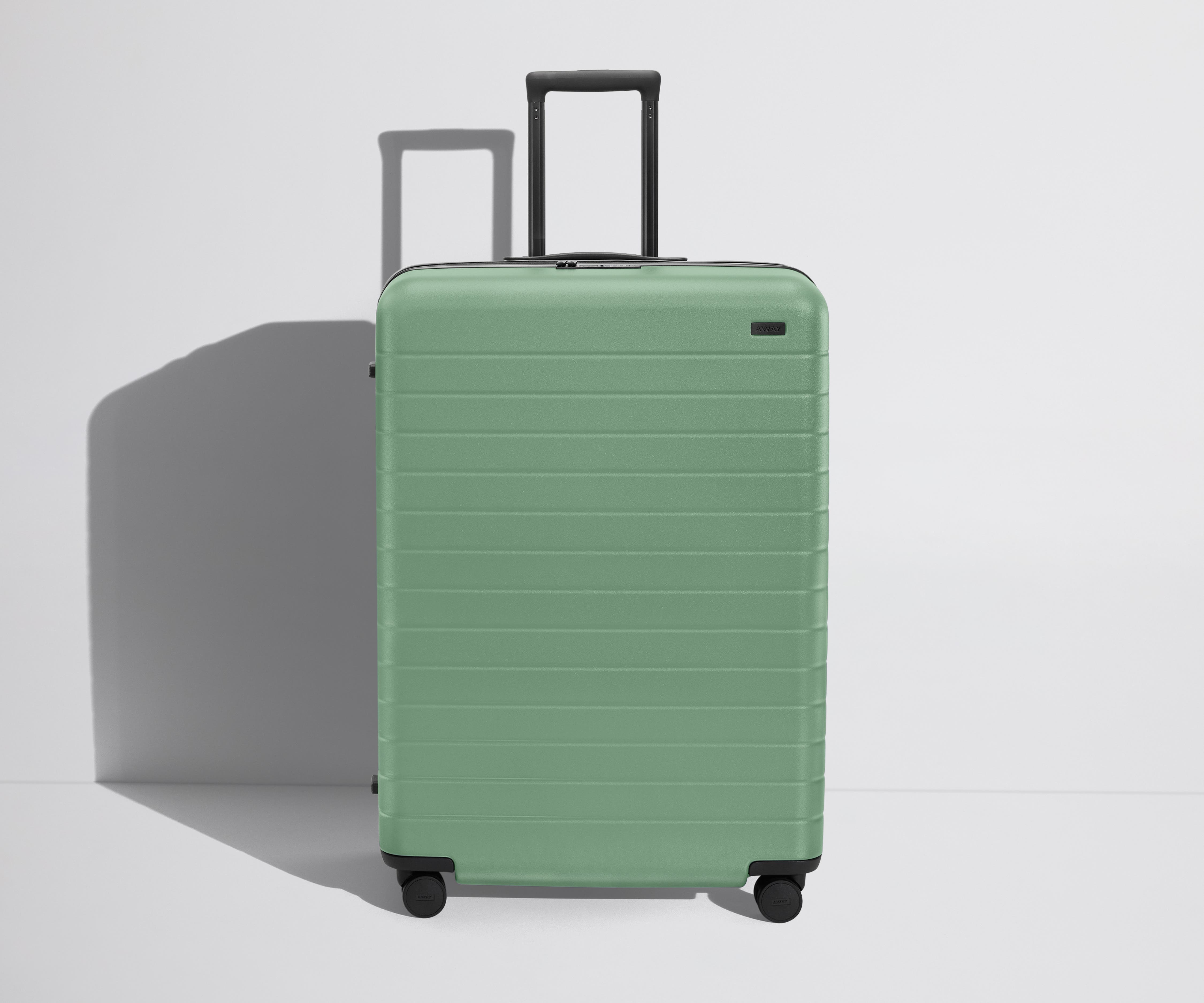 Front product view of The Large Flex suitcase in Sea Green with raised handle