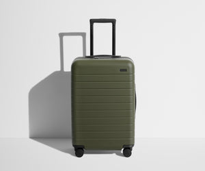 Front product view of The Bigger Carry-On suitcase in Olive Green with raised handle