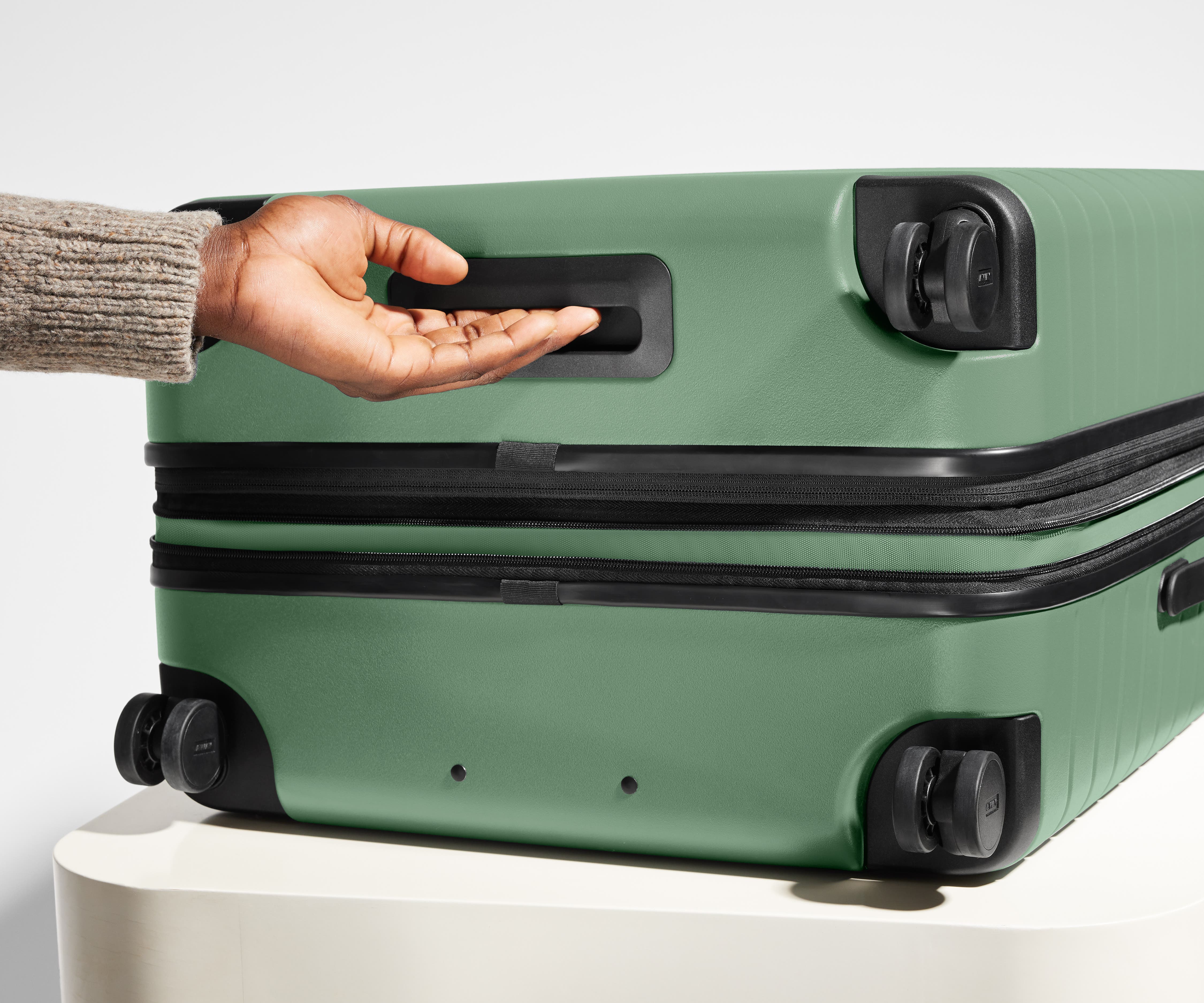 The Large Flex suitcase in Sea Green shown from below highlighting the underside grab handle