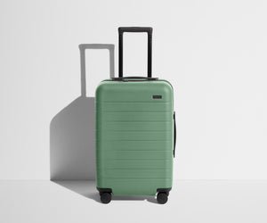 Front product view of The Carry-On suitcase in Sea Green with raised handle