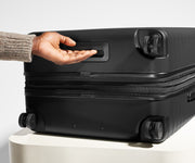 The Large Flex suitcase in Jet Black shown from below highlighting the underside grab handle