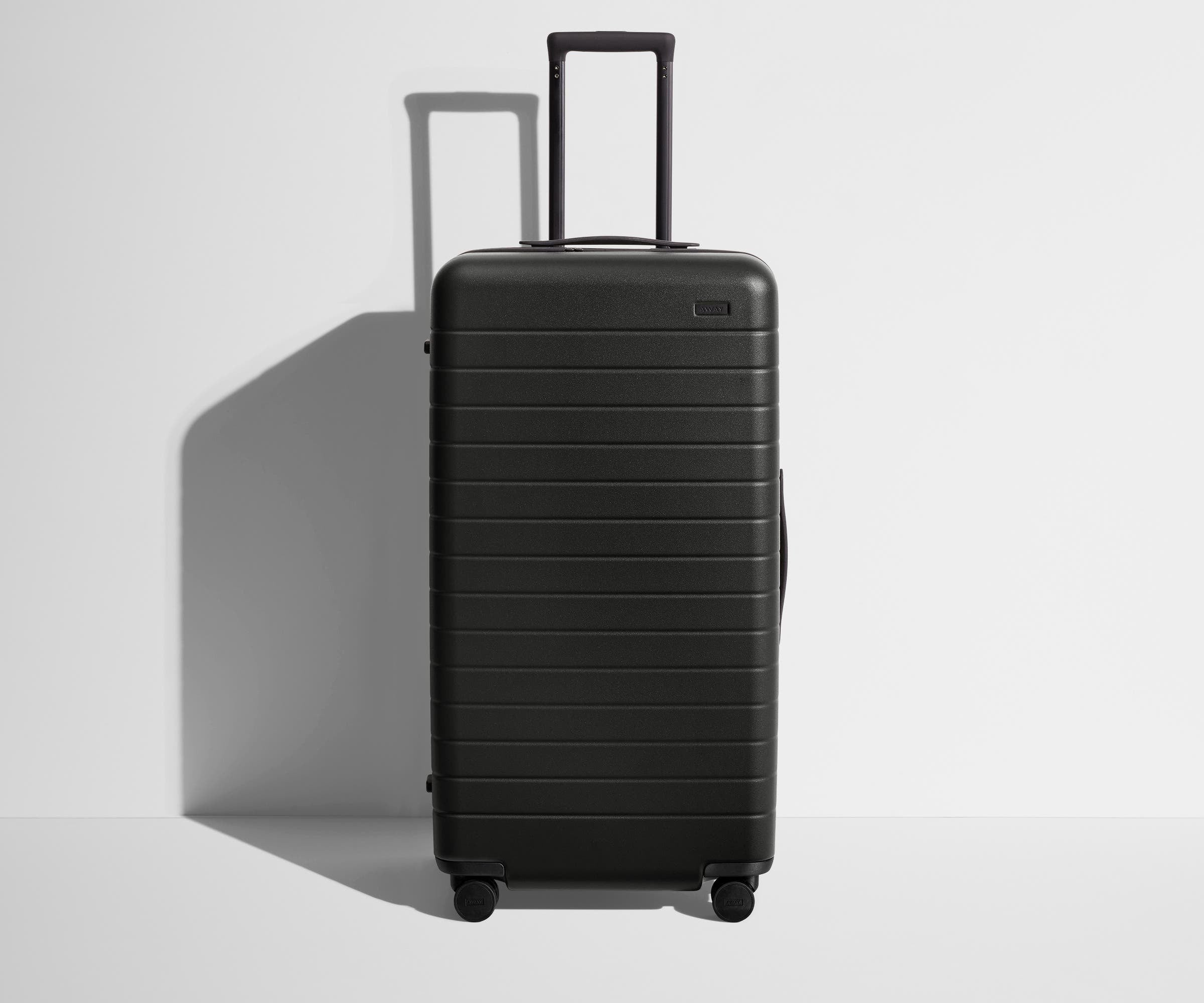 Front product view of The Trunk suitcase in Jet Black with raised handle