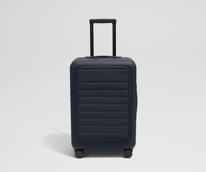 Front product view of The Front Pocket Bigger Carry-On suitcase in Navy Blue with raised handle