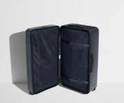 The Trunk suitcase in Navy Blue shown open in an upright position to show interior organization and compression system