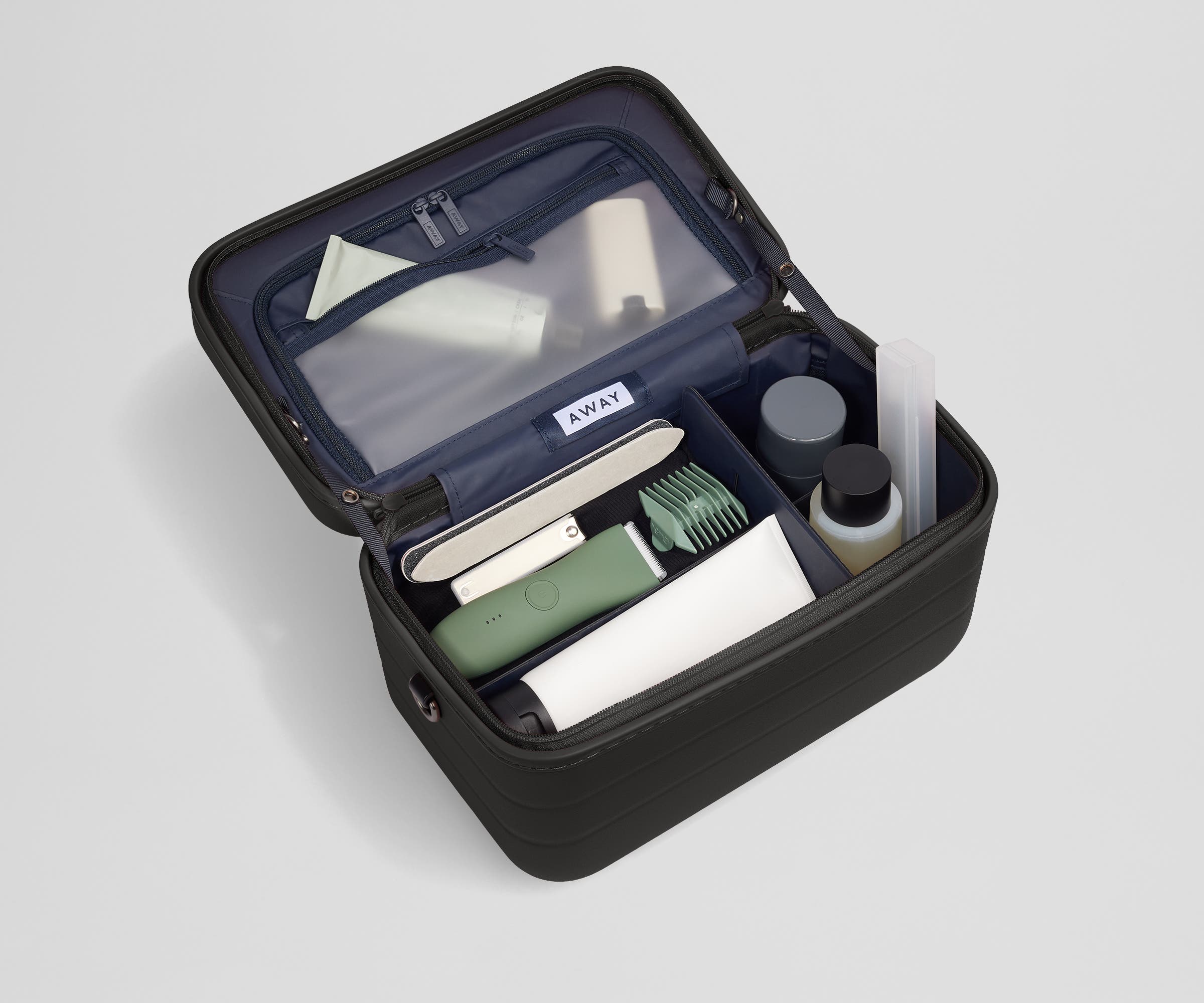 Train case packed with multiple grooming essentials, including a razor, nail care, and lotions