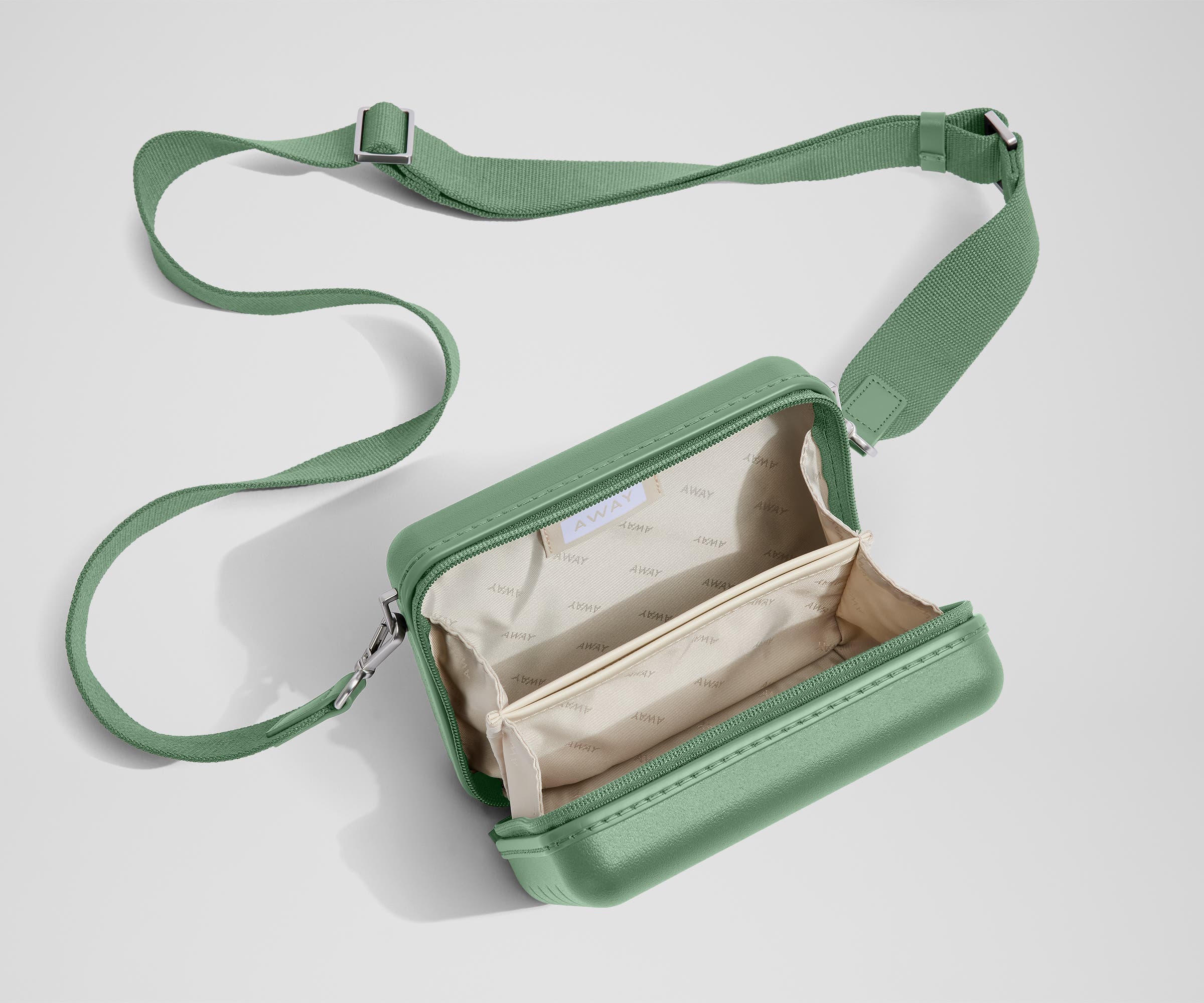 Unzipped, open view of The Mini Crossbody, showing the two main compartments and slip pocket